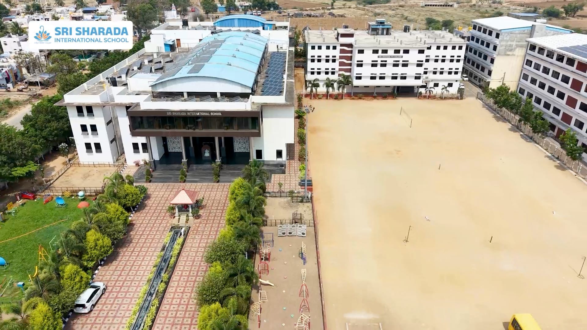 The Sri Sharada International School campus from the air — the porch, the playing field and the classroom blocks across seven acres