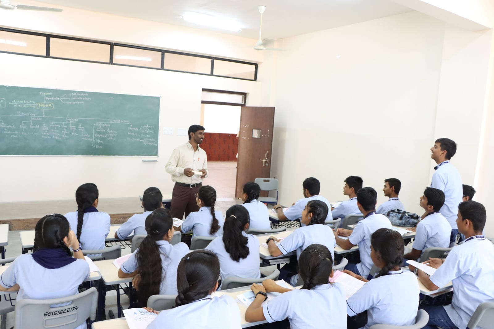 A Sri Sharada PU College lecture in progress — students at their desks, the teacher at the board